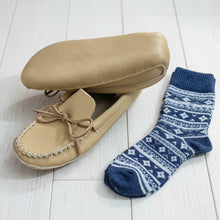 Load image into Gallery viewer, A pair of beige men's moose hide moccasins with an adjustable lace and a triple sole design, displayed on a wooden floor.