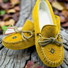 Load image into Gallery viewer, A pair of yellow ladies' moose hide suede moccasins with beadwork, displayed on a natural outdoor background with leaves and a piece of wood.