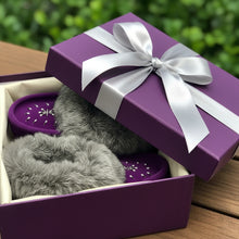 Load image into Gallery viewer, A pair of purple Laurentian Chief Moccasins with rabbit fur trim and silver bead detailing, displayed alongside red roses on a wooden surface.