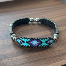 Load image into Gallery viewer, Beaded bracelet with a geometric pattern on a wooden surface