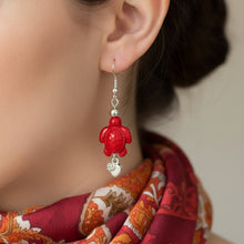 Load image into Gallery viewer, Red turtle-shaped earrings on a Mocs N More branded card.