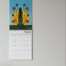 Load image into Gallery viewer, Calendar open to August on a tiled floor
