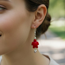 Load image into Gallery viewer, Red turtle-shaped earrings on a Mocs N More branded card.