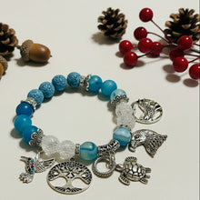 Load image into Gallery viewer, Blue beaded bracelet with various charms on a light background