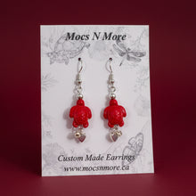 Load image into Gallery viewer, Red turtle-shaped earrings on a Mocs N More branded card.