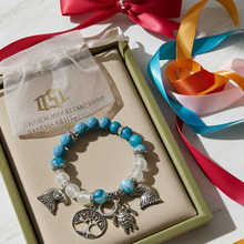 Load image into Gallery viewer, Bracelet with charms on a beige mat with colorful ribbons in the background