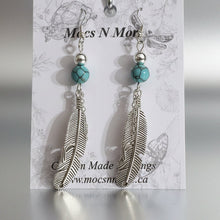 Load image into Gallery viewer, Feather-shaped earrings with turquoise beads on a Mocs N More branded card.