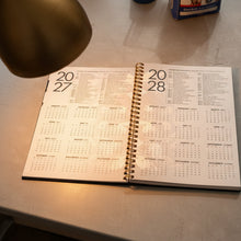 Load image into Gallery viewer, Calendar with 2028 layout on a concrete surface