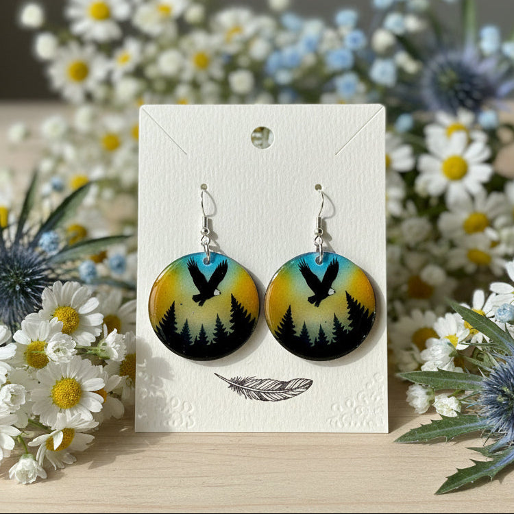 Pair of earrings on a card with flowers in the background