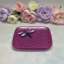 Load image into Gallery viewer, A square glittery purple tray with rounded corners and a small dragonfly decoration on top, placed on a light stone surface.