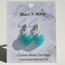 Load image into Gallery viewer, Turquoise heart-shaped earrings on a Mocs N More branded card.