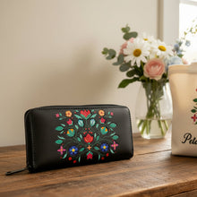 Load image into Gallery viewer, Black wallet with colorful floral design on a reflective surface