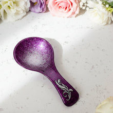 Load image into Gallery viewer, Purple glittery spoon rest with a decorative design on a gray surface