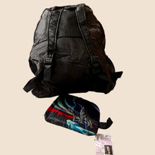 Load image into Gallery viewer, Black backpack on a white surface with a colorful bag and ID card nearby, in an indoor setting.