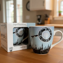 Load image into Gallery viewer, White mug with black and gray design next to its packaging on a white surface.