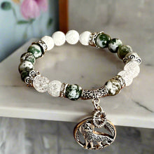 Load image into Gallery viewer, Bracelet with green and white beads and an elephant charm on a wooden surface
