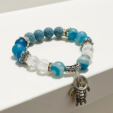 Load image into Gallery viewer, Bracelet with blue and clear beads and a turtle charm on a white surface