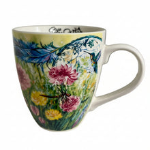 Load image into Gallery viewer, A white ceramic mug with a colorful floral and bird illustration, sitting on a white shelf against a white background.