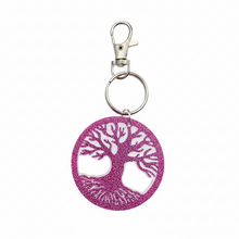 Load image into Gallery viewer, A circular pink glitter keychain featuring a tree of life design with cutouts, attached to a silver metal split ring and lobster clasp, shown on a plain white background.