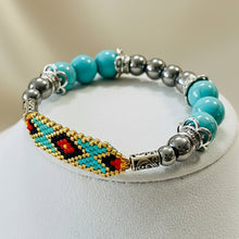 Load image into Gallery viewer, Beaded bracelet with turquoise, silver, and multicolored beads on a wooden surface