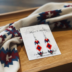Earrings on a card with a patterned fabric background