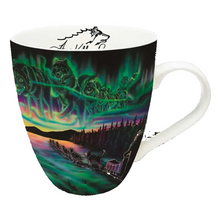 Load image into Gallery viewer, A white ceramic coffee mug featuring a vibrant, full-wrap print of the Northern Lights (aurora borealis) over a forest landscape with reindeer and a cabin. The inside of the mug is white with a black line-art graphic of a wolf.