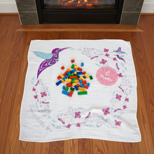 Load image into Gallery viewer, Baby milestone blanket with colorful blocks on a wooden floor in front of a fireplace.