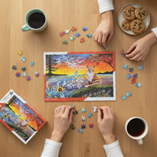 Load image into Gallery viewer, Overhead view of hands working on Daytime Dreamer puzzle with tea and snacks