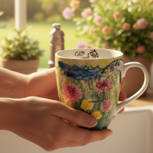 Load image into Gallery viewer, Dreamcatcher mug held near a kitchen window overlooking a garden