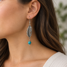 Load image into Gallery viewer, Model wearing the silver feather earring with round blue bead end