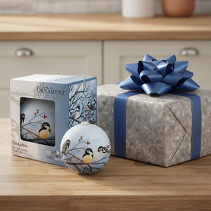 Decorative glass ornament with chickadees on branches, displayed with packaging.