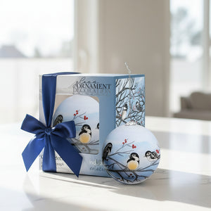 Decorative glass ornament with chickadees on branches, displayed with packaging.