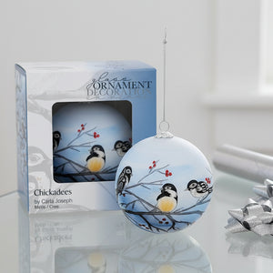Decorative glass ornament with chickadees on branches, displayed with packaging.