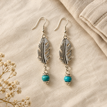 Load image into Gallery viewer, Styled flat lay of the silver feather earrings